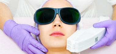 Mujer en sesión de depilación facial con gafas protectoras de láser y luz pulsada